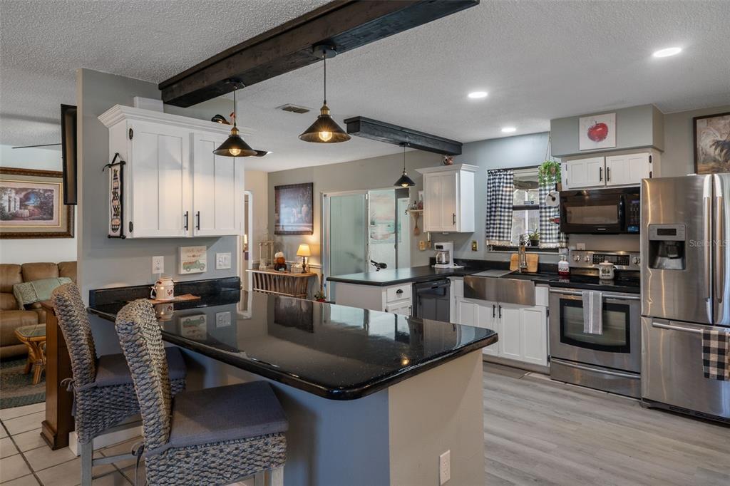 7311 Edinburgh Way Weeki Wachee, FL 34613 - Photo 7 of 27 a kitchen with granite countertop a sink appliances and cabinets