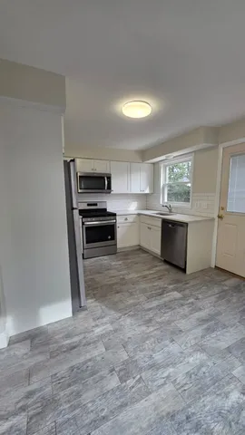 a view of kitchen with sink microwave and cabinets