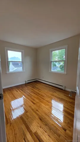 a view of a room with wooden floor and window
