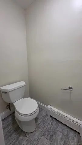a white toilet sitting next to a shower
