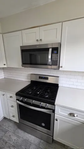 a kitchen with microwave stove and cabinets