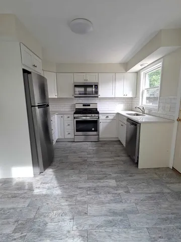 a kitchen with stainless steel appliances granite countertop a refrigerator and a sink