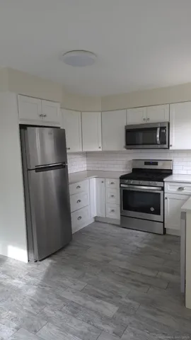 a kitchen with a refrigerator and a stove