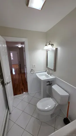 a bathroom with a toilet a sink and mirror