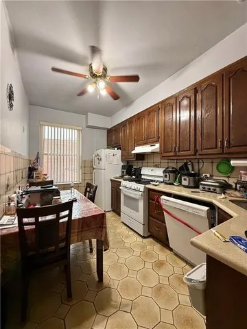 a kitchen with kitchen island granite countertop a sink appliances cabinets and furniture