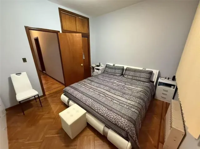 a bedroom with a bed window and mirror