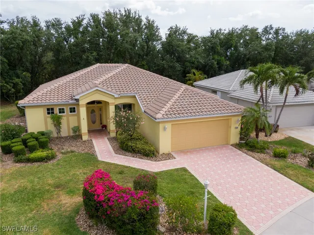 a front view of a house with a yard and potted plants