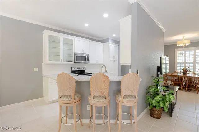 a dining room with furniture a potted plant and open kitchen view