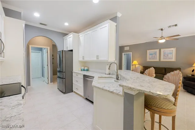 a large kitchen with stainless steel appliances kitchen island granite countertop a refrigerator a sink and a stove with wooden floor