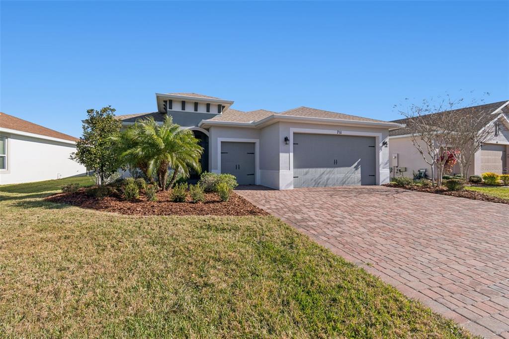 711 San Joaquin Road Kissimmee, FL 34759 - Photo 3 of 41 a view of a house with a small yard and a large tree