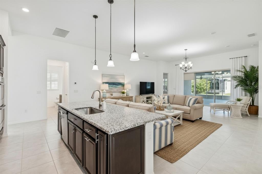 711 San Joaquin Road Kissimmee, FL 34759 - Photo 6 of 41 a view of kitchen island a sink a counter space and living room view