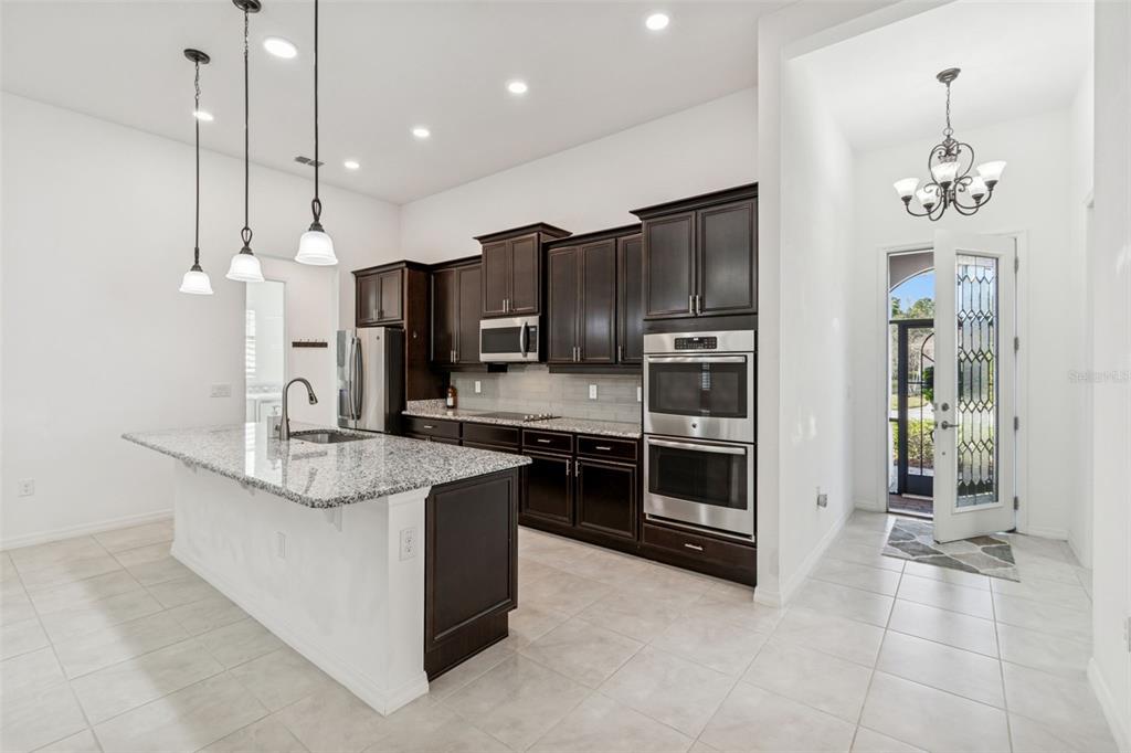 711 San Joaquin Road Kissimmee, FL 34759 - Photo 7 of 41 a kitchen with stainless steel appliances kitchen island granite countertop a stove a sink and a refrigerator