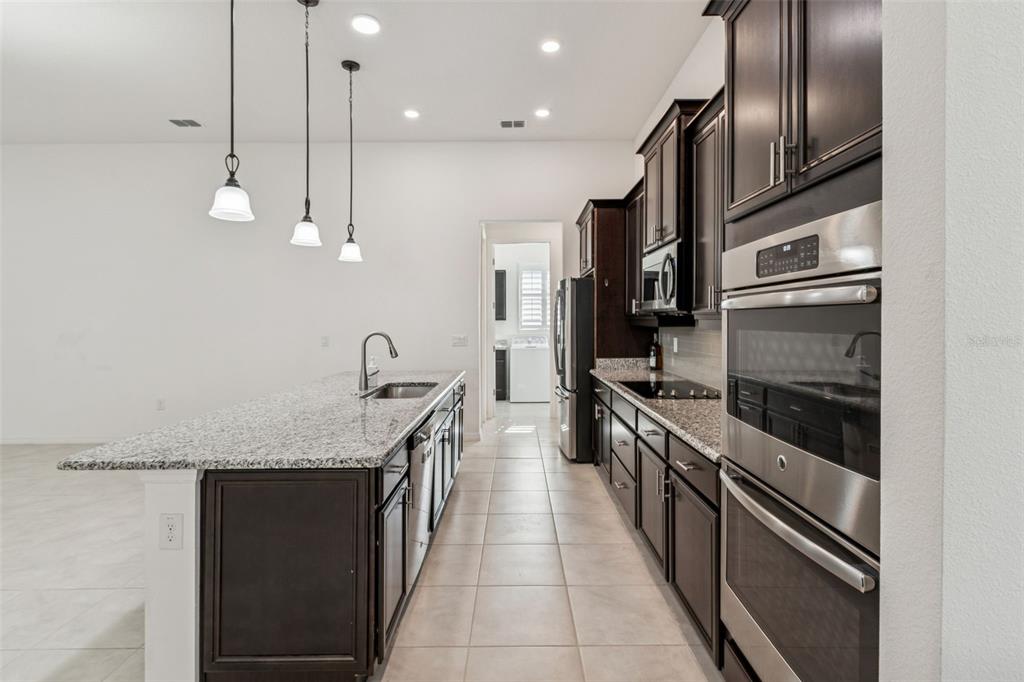 711 San Joaquin Road Kissimmee, FL 34759 - Photo 10 of 41 a kitchen with stainless steel appliances granite countertop a stove top oven a sink and dishwasher