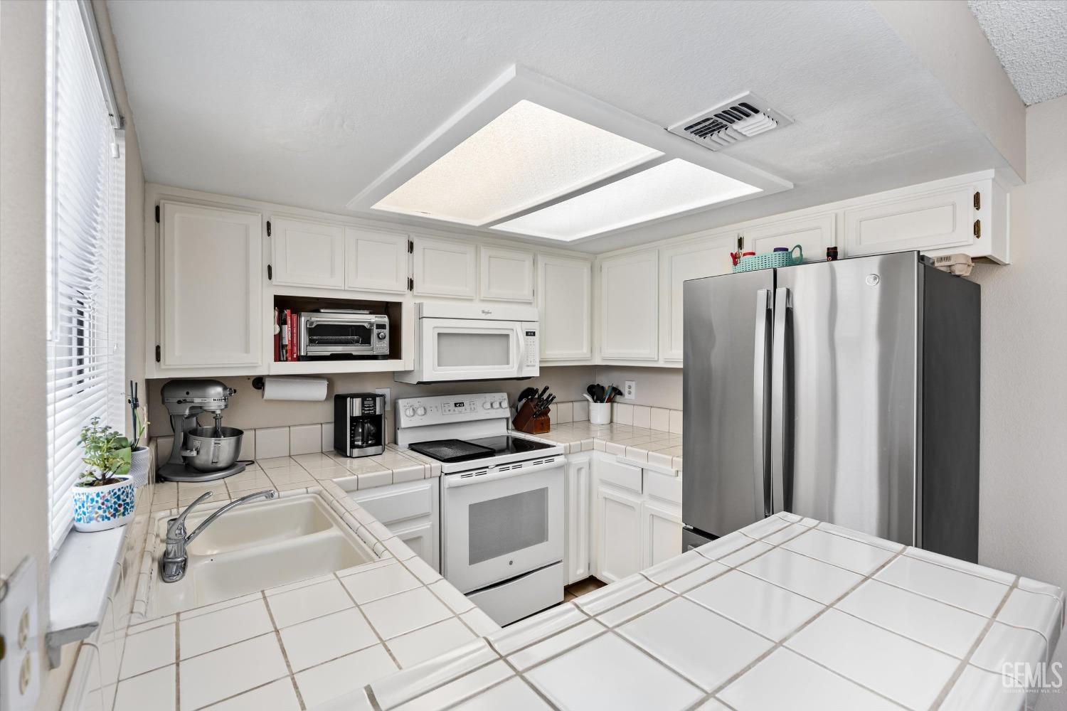 Undisclosed Address Bakersfield, CA 93311 - Photo 11 of 33 a kitchen with stainless steel appliances a refrigerator sink and microwave