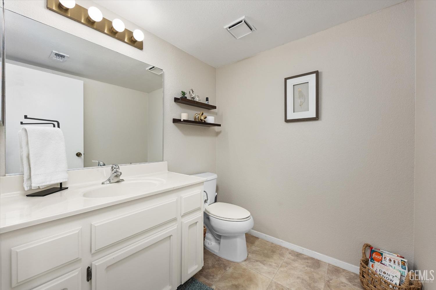 Undisclosed Address Bakersfield, CA 93311 - Photo 14 of 33 a bathroom with a toilet a sink and mirror