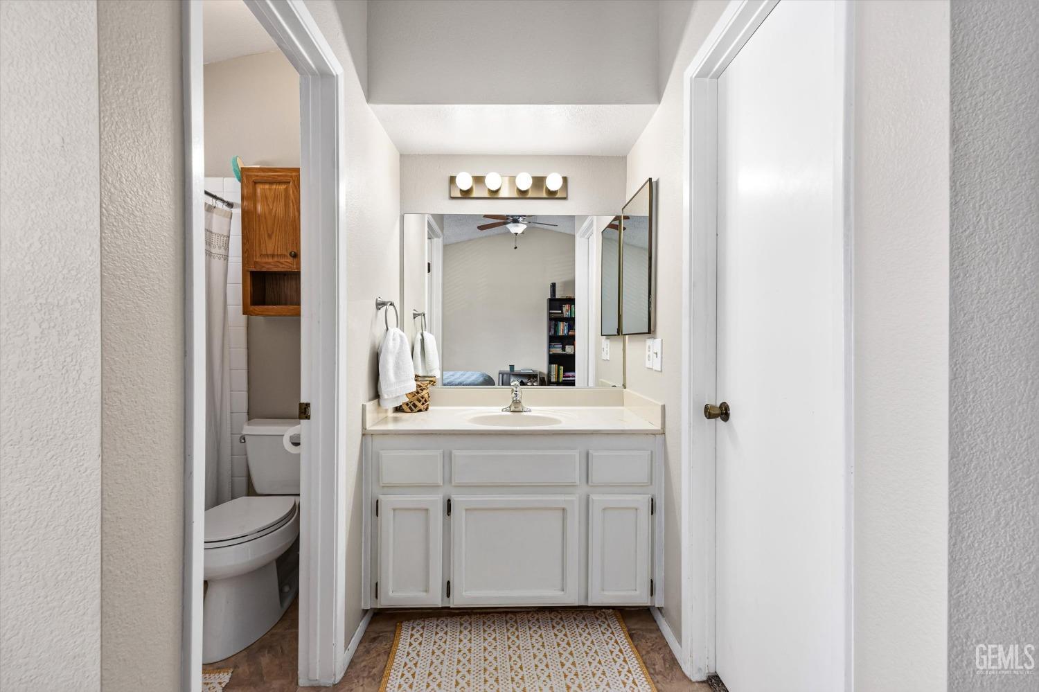 Undisclosed Address Bakersfield, CA 93311 - Photo 18 of 33 a bathroom with a granite countertop sink a toilet and a mirror