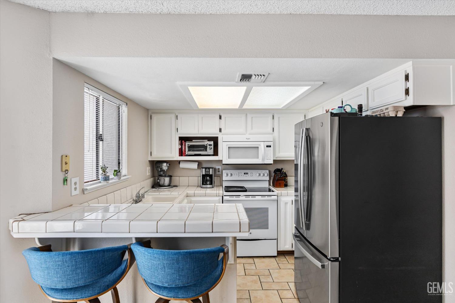 Undisclosed Address Bakersfield, CA 93311 - Photo 10 of 33 a kitchen with stainless steel appliances a refrigerator a sink a stove a microwave and cabinets