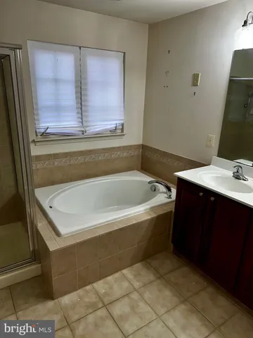 a bathroom with a bathtub sink and cabinets