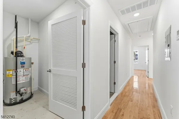 a view of a hallway with wooden floor and closet