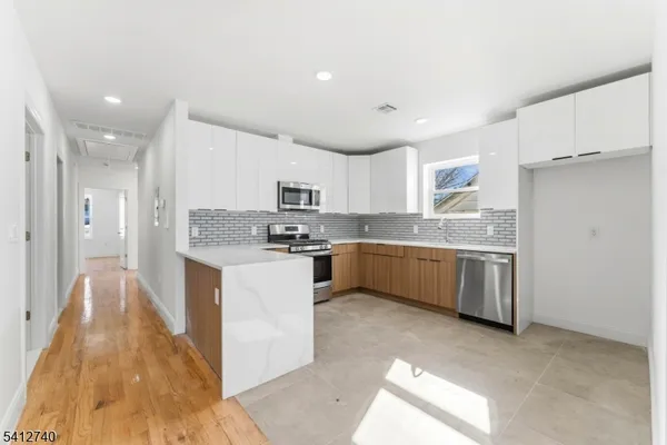 a large kitchen with kitchen island a sink stainless steel appliances and cabinets