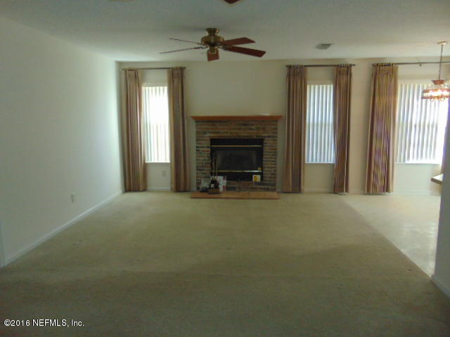 1115 Copper Field Circle Macclenny, FL 32063 - Photo 11 of 40 a view of an empty room with a fireplace and a window