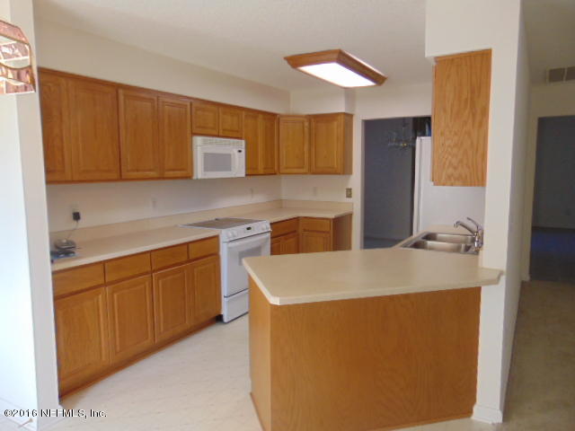 1115 Copper Field Circle Macclenny, FL 32063 - Photo 4 of 40 a kitchen with stainless steel appliances granite countertop a sink a refrigerator and a cabinets