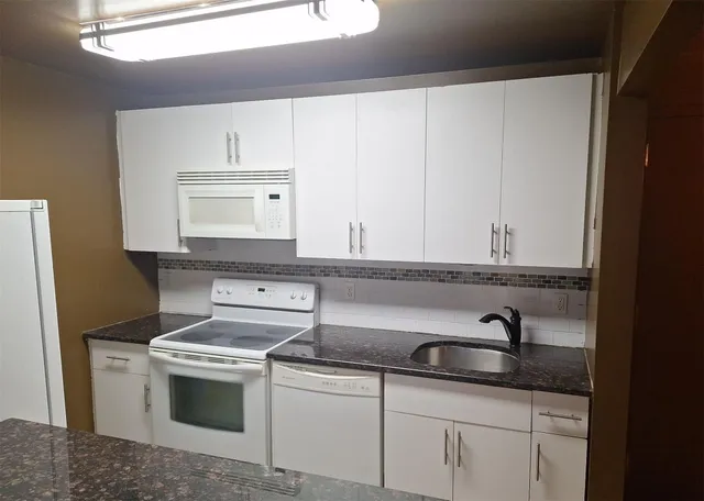 a sink with white cabinets