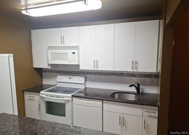 a sink with white cabinets