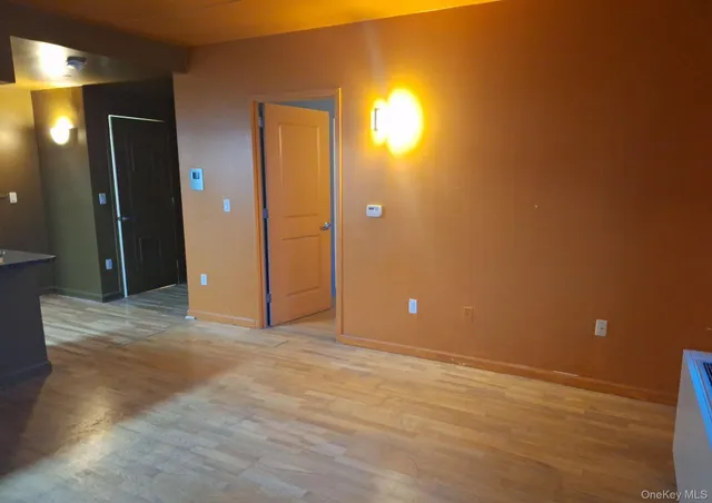 a view of an empty room with window and a bathroom