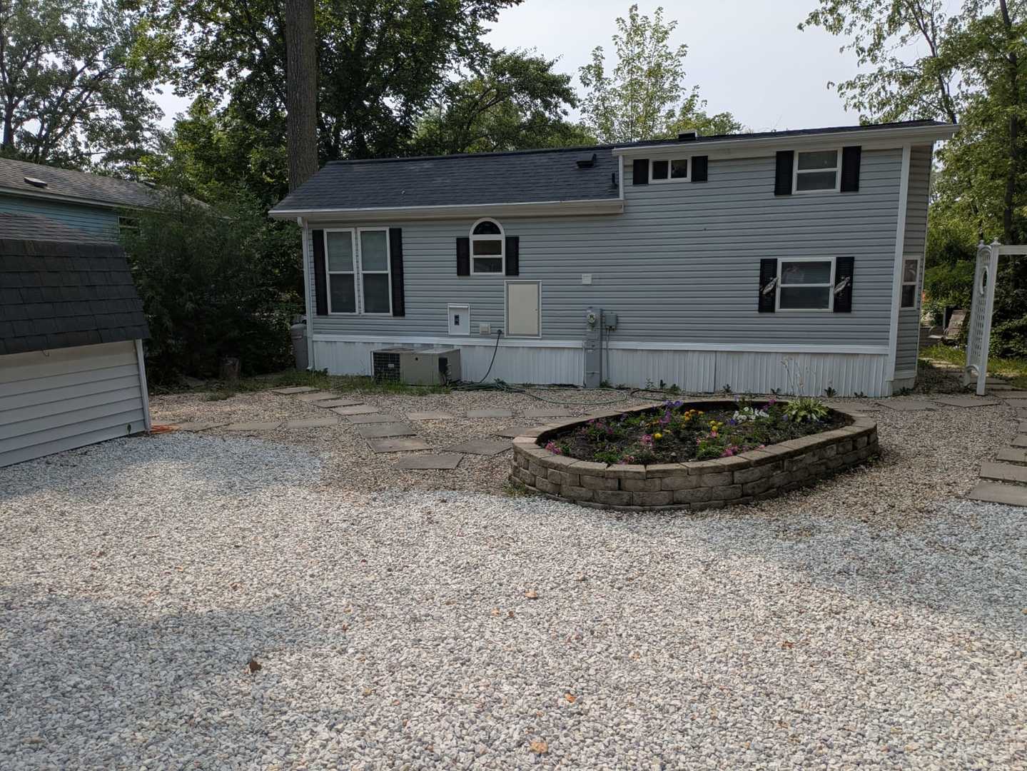 a view of a backyard with plants and a tree
