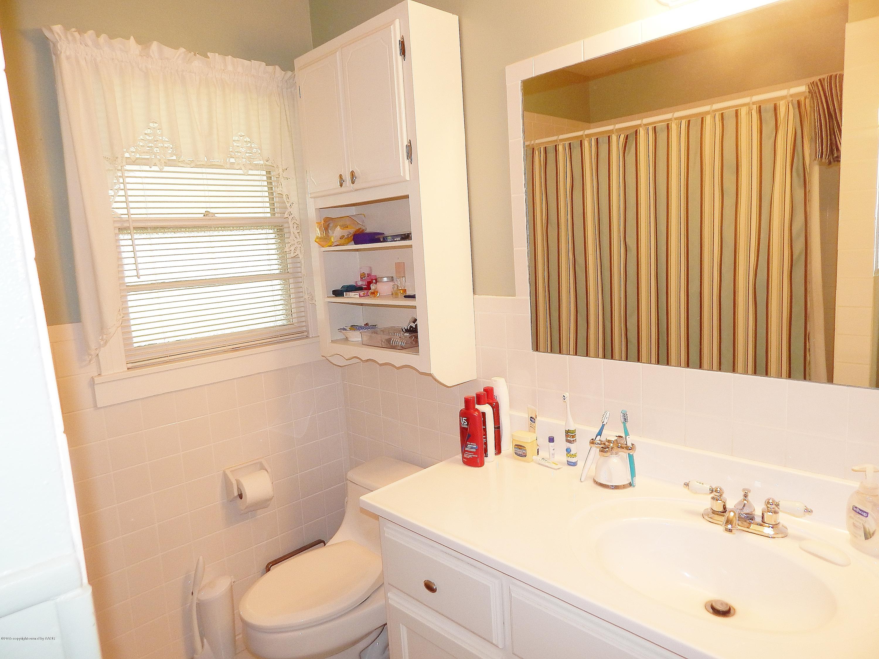 4310 South Ong Street Amarillo, TX 79110 - Photo 7 of 13 a bathroom with a sink vanity mirror and toilet