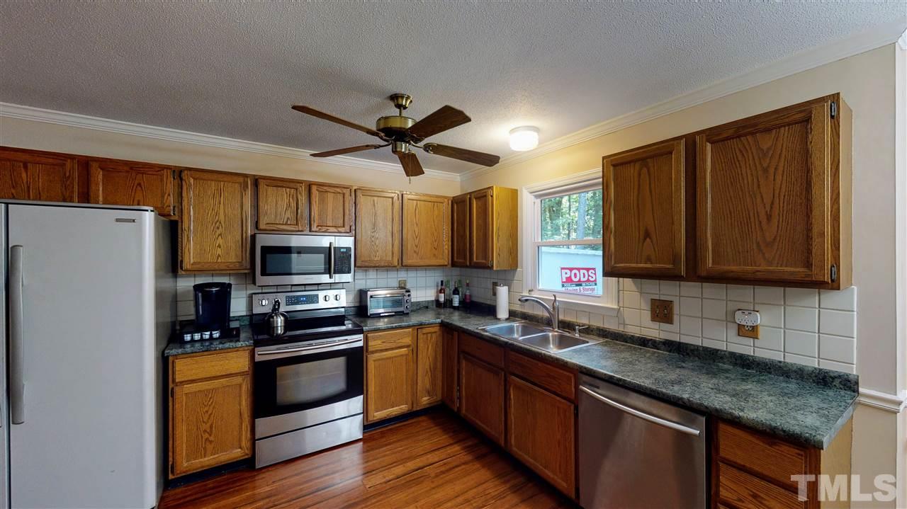 123 Abercrombie Road Wake Forest, NC 27587 - Photo 11 of 27 a kitchen with kitchen island granite countertop a sink stainless steel appliances and cabinets