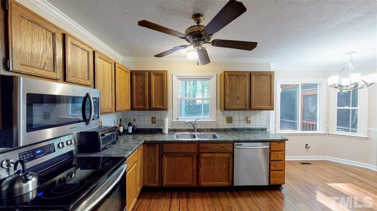 123 Abercrombie Road Wake Forest, NC 27587 - Photo 12 of 27 a kitchen with granite countertop a stove a sink and wooden cabinets