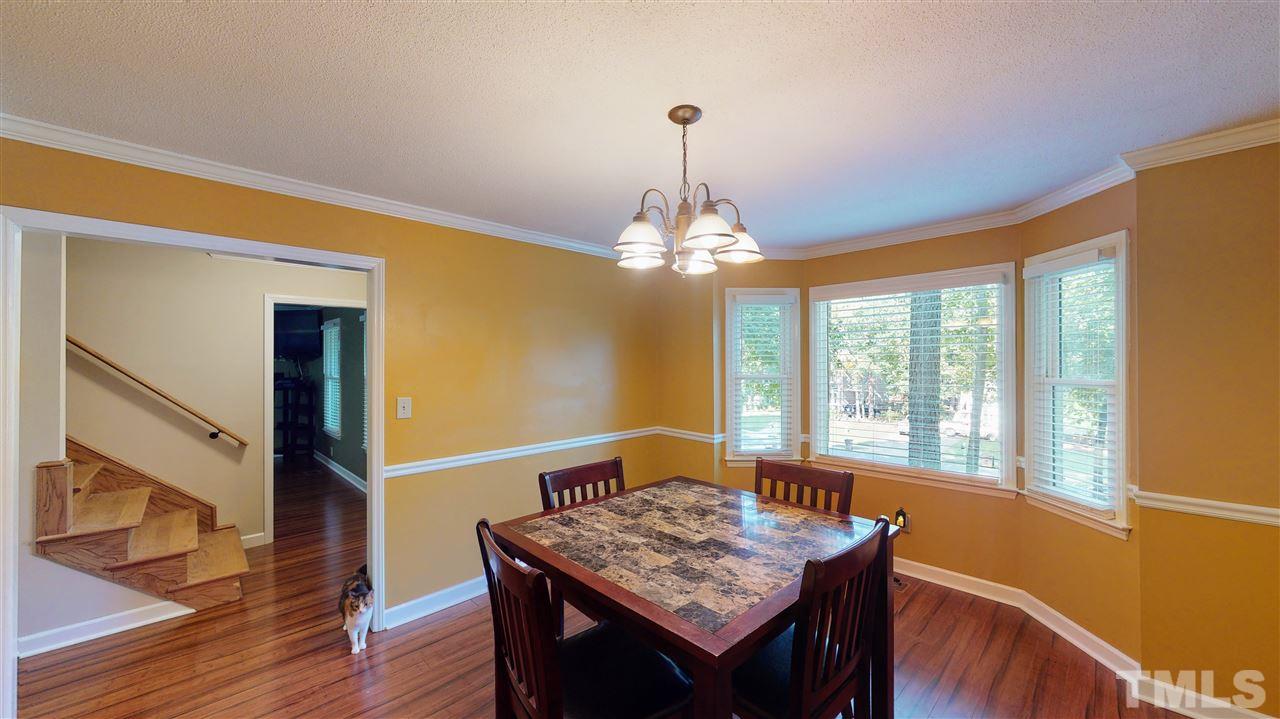 123 Abercrombie Road Wake Forest, NC 27587 - Photo 13 of 27 a dining room with wooden floor a chandelier a wooden table and chairs