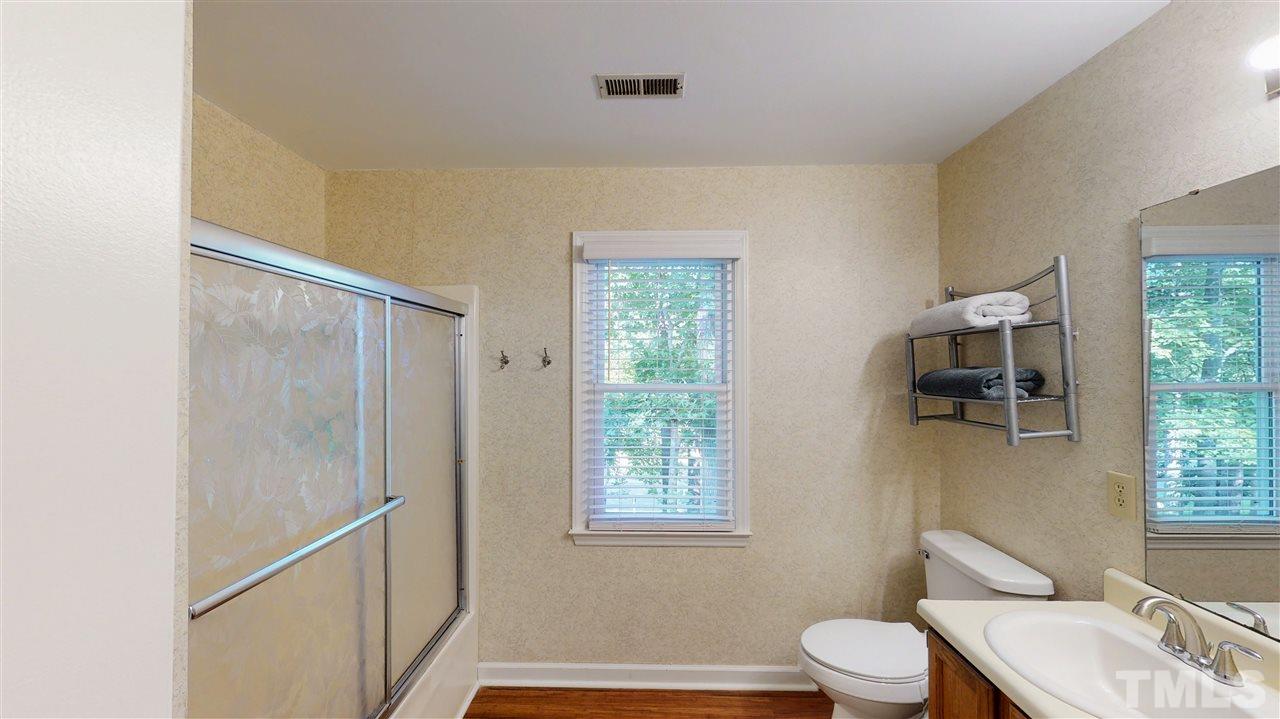 123 Abercrombie Road Wake Forest, NC 27587 - Photo 20 of 27 a bathroom with a toilet sink a window and shower