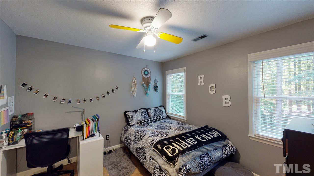 123 Abercrombie Road Wake Forest, NC 27587 - Photo 22 of 27 a bedroom with a bed and a chandelier