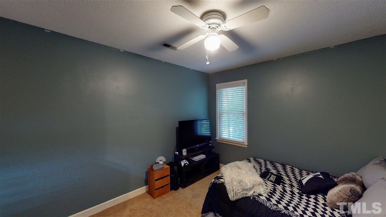 123 Abercrombie Road Wake Forest, NC 27587 - Photo 24 of 27 a bedroom with a bed and a chandelier