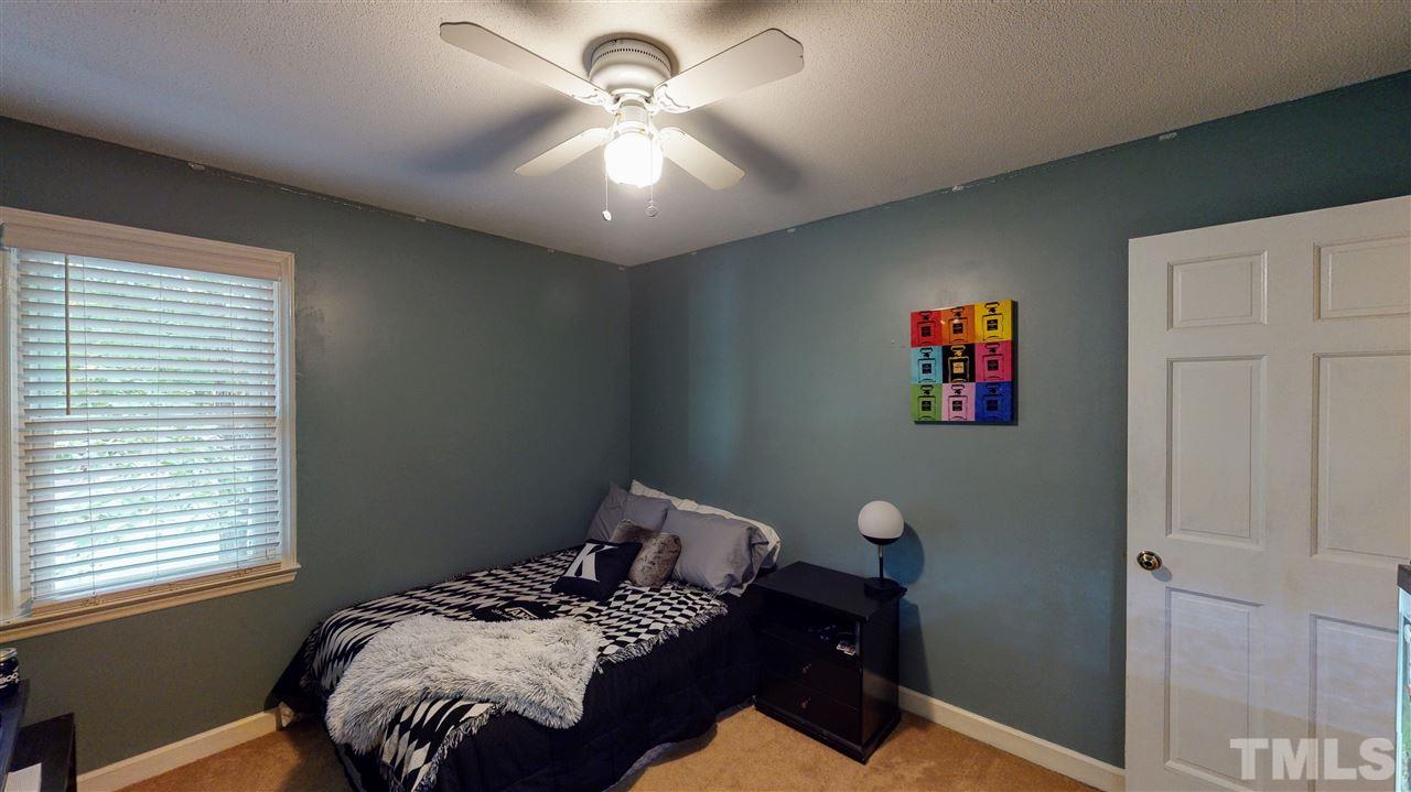 123 Abercrombie Road Wake Forest, NC 27587 - Photo 25 of 27 a bedroom with a bed and a chandelier