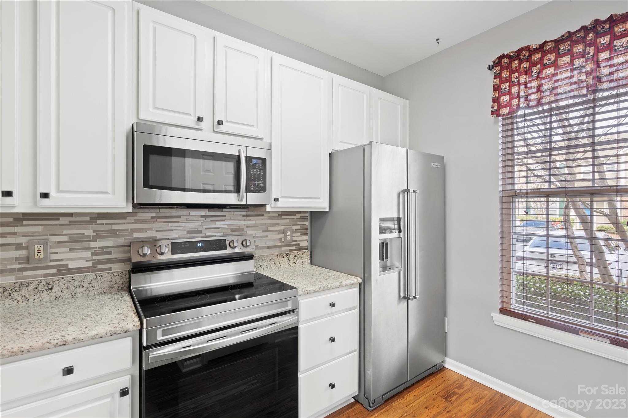 1103 Sienna Sand Way Fort Mill, SC 29708 - Photo 8 of 26 a kitchen with granite countertop white cabinets and stainless steel appliances