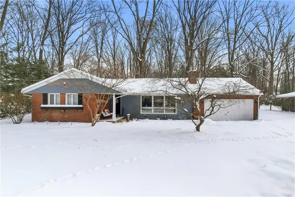 a front view of a house with a yard covered with snow in front of house