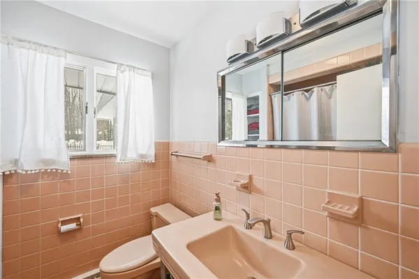 a bathroom with a sink mirror toilet and shower