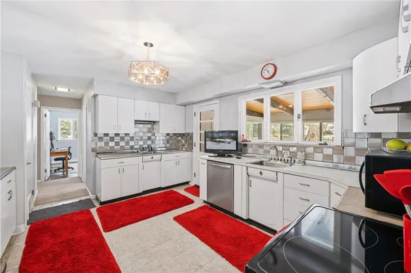 a kitchen with white cabinets and sink