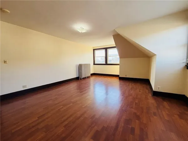 a view of a room with wooden floor and window