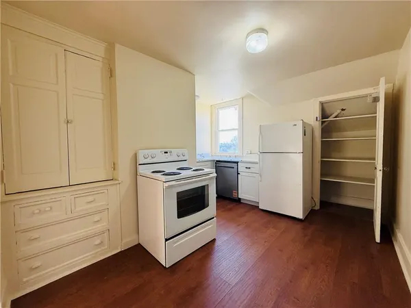 a kitchen with a white stove and refrigerator