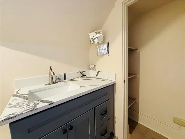 a bathroom with a granite countertop sink and a mirror