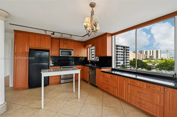 a kitchen with stainless steel appliances granite countertop a stove a sink dishwasher and a microwave oven with cabinets