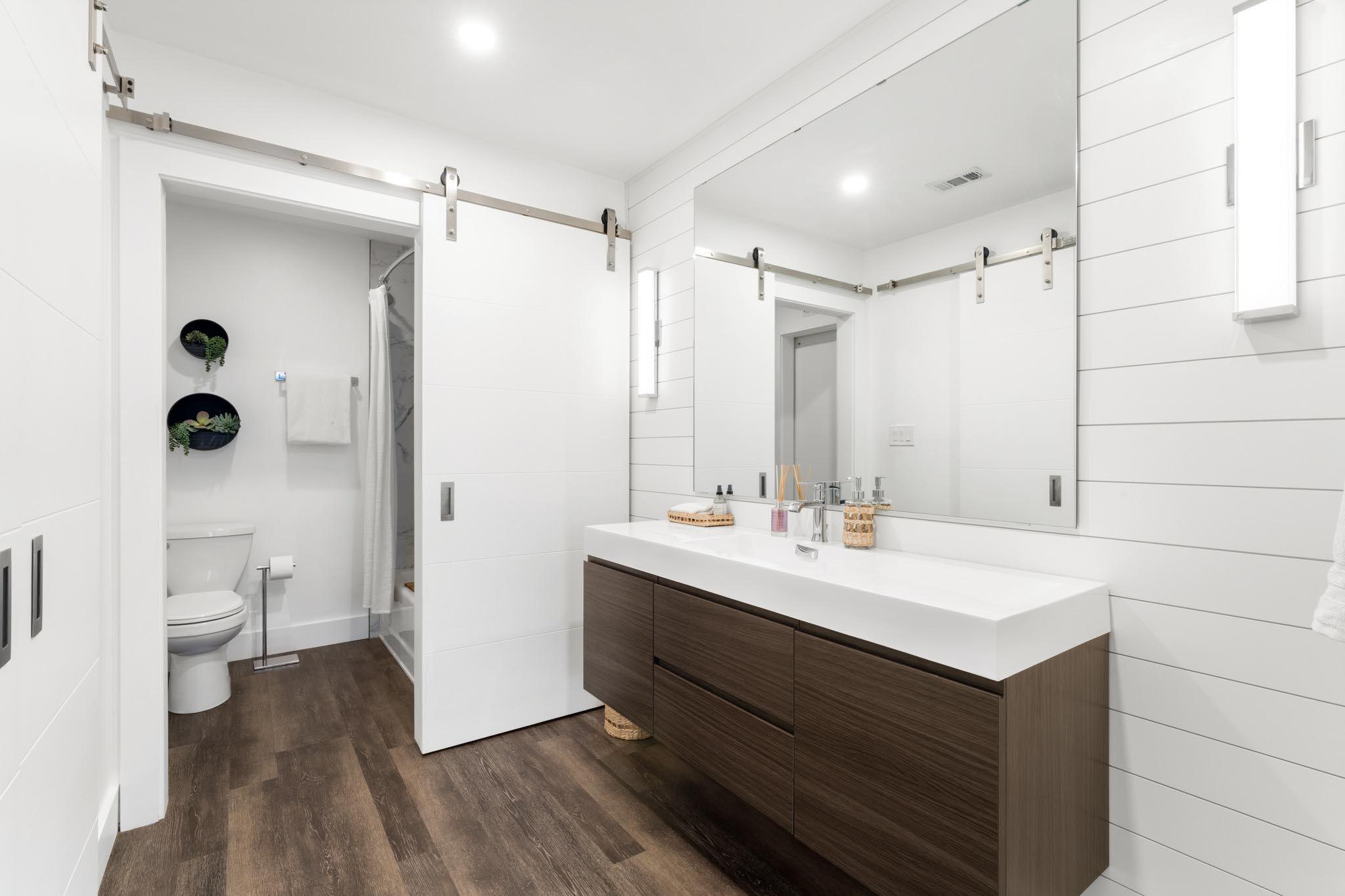 130 Durango Road, Unit 104 Destin, FL 32541 - Photo 29 of 46 a bathroom with a sink a toilet and a large mirror
