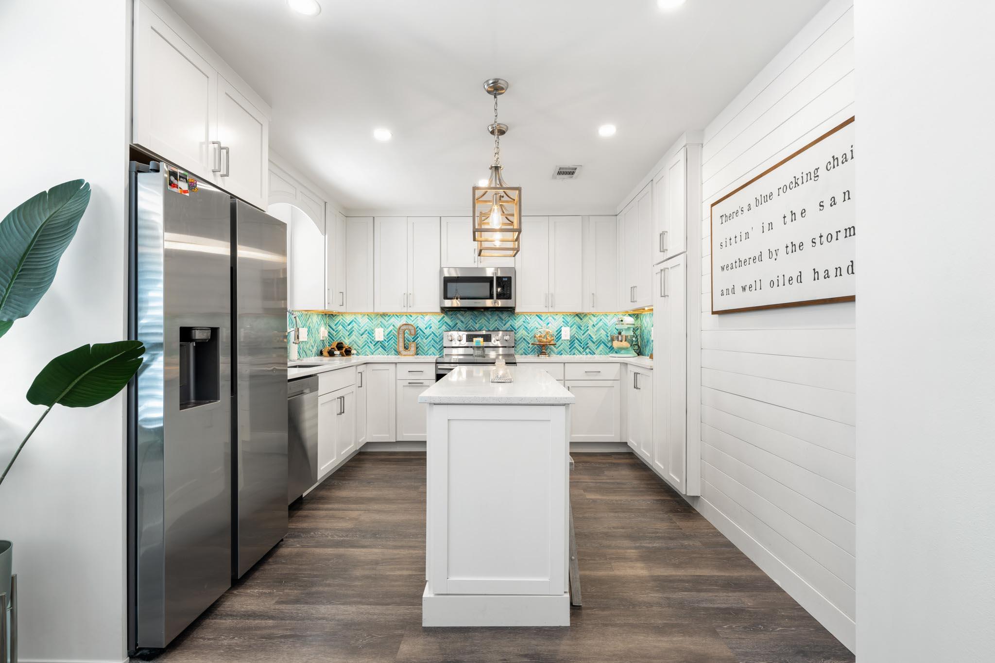 130 Durango Road, Unit 104 Destin, FL 32541 - Photo 9 of 46 a kitchen with white cabinets and white appliances