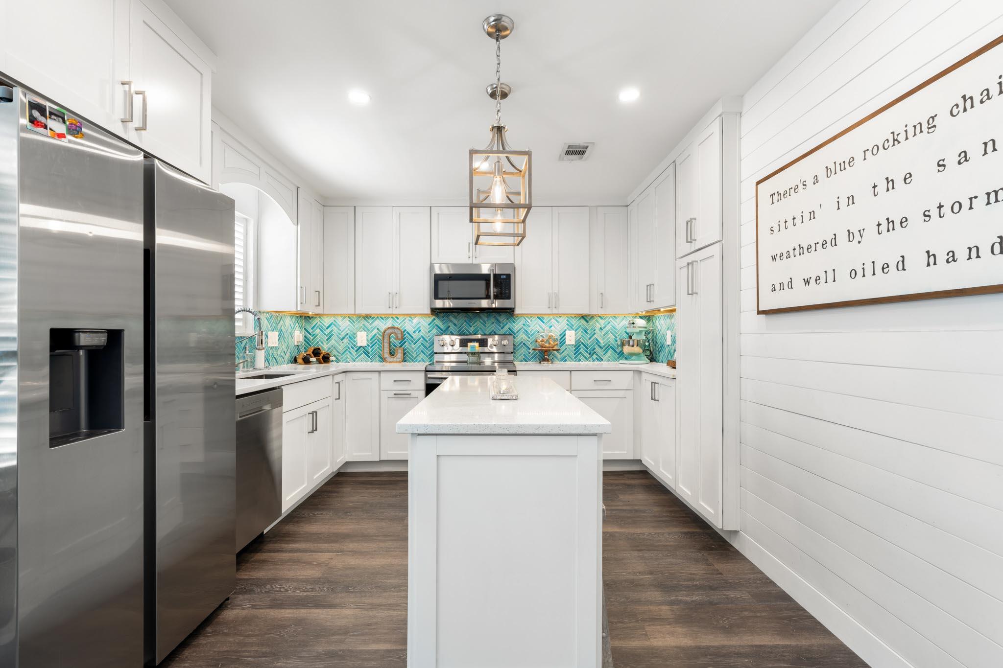 130 Durango Road, Unit 104 Destin, FL 32541 - Photo 10 of 46 a kitchen with white cabinets and stainless steel appliances