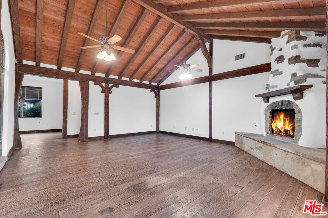 32140 Windrush Road Agua Dulce, CA 91390 - Photo 12 of 41 a view of an empty room with wooden floor fireplace and a window